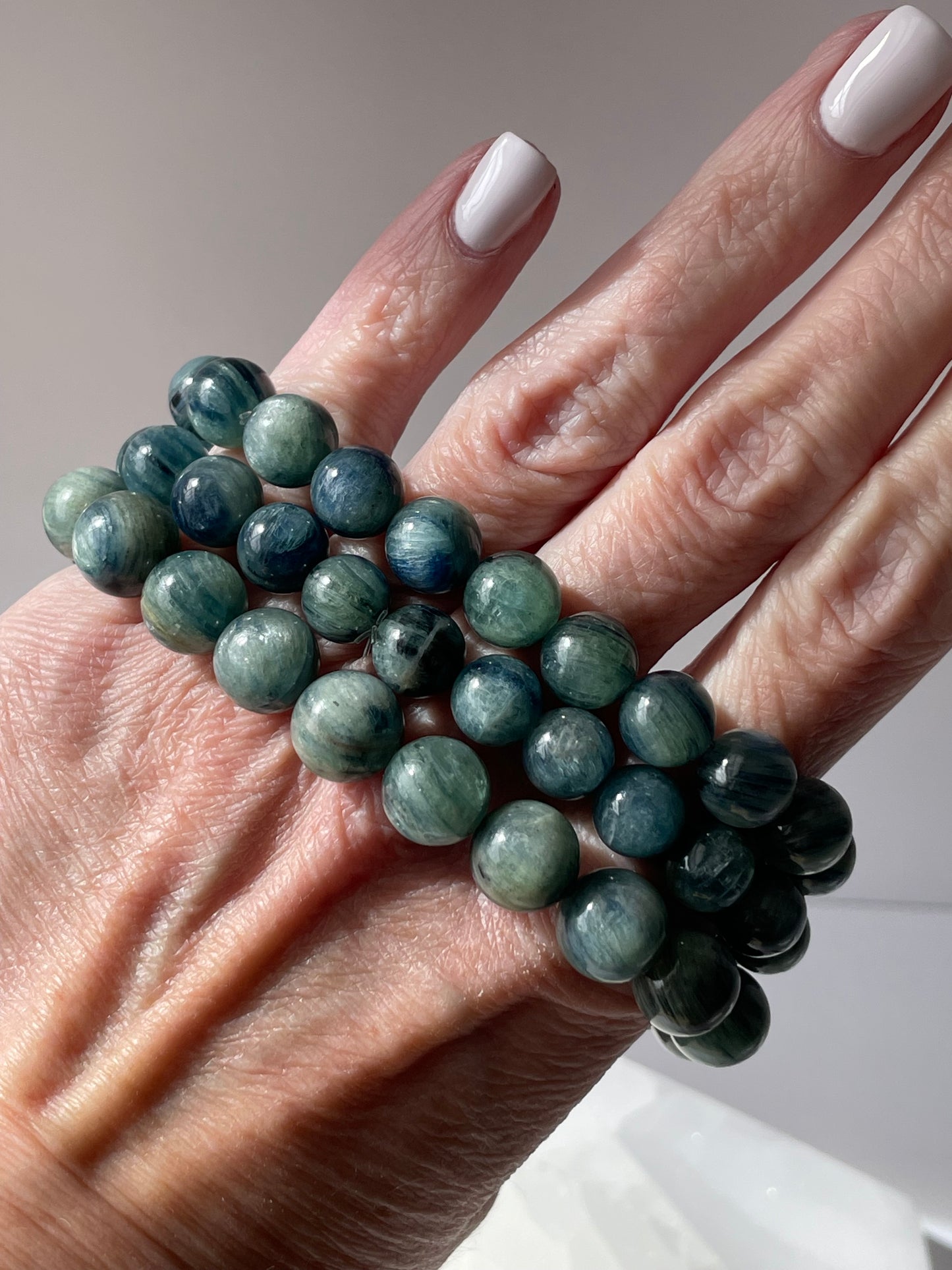 Blue Kyanite bracelet displayed on a woman’s hand.