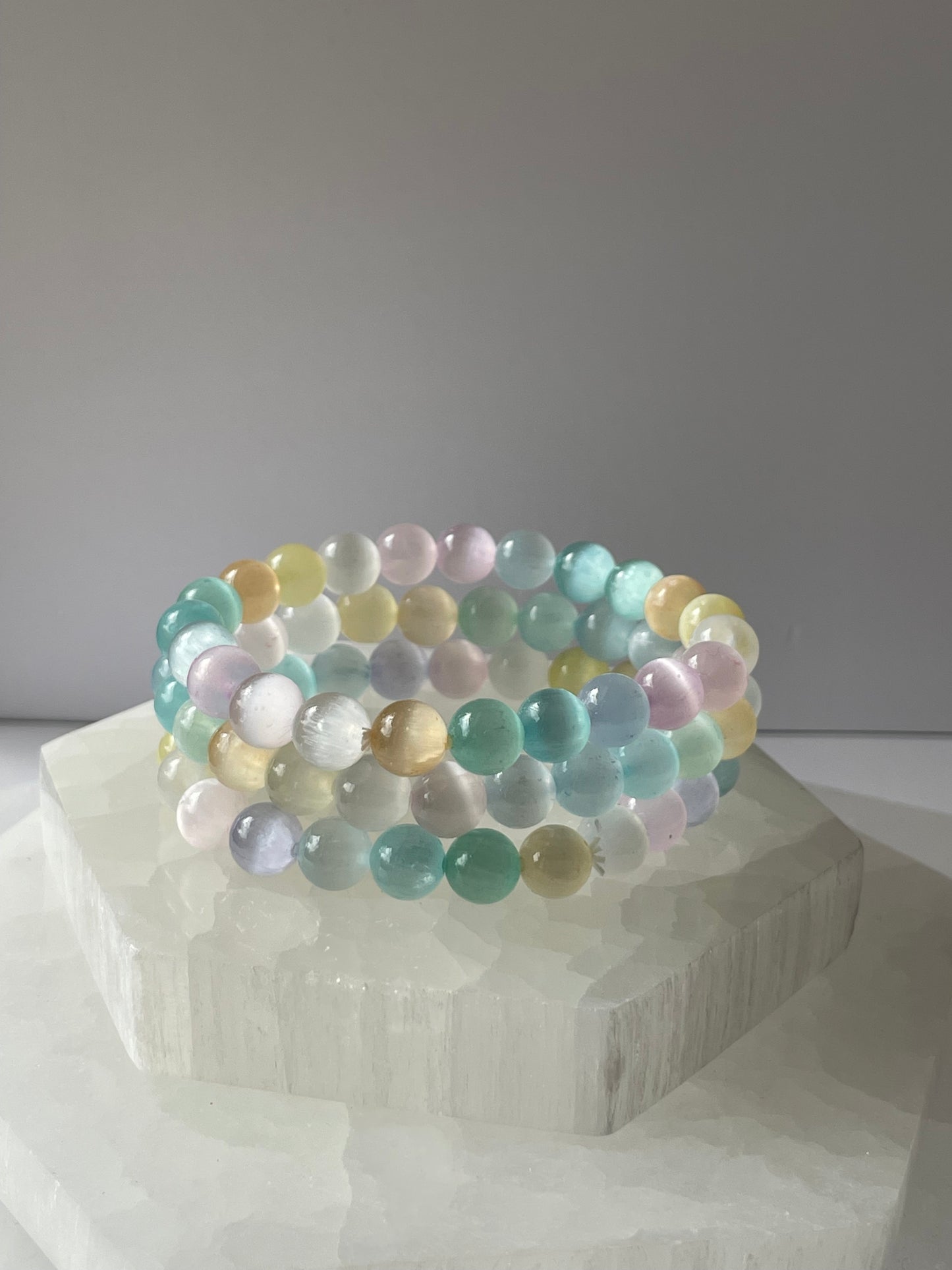 Multicolored Selenite beaded bracelet resting on a white crystal