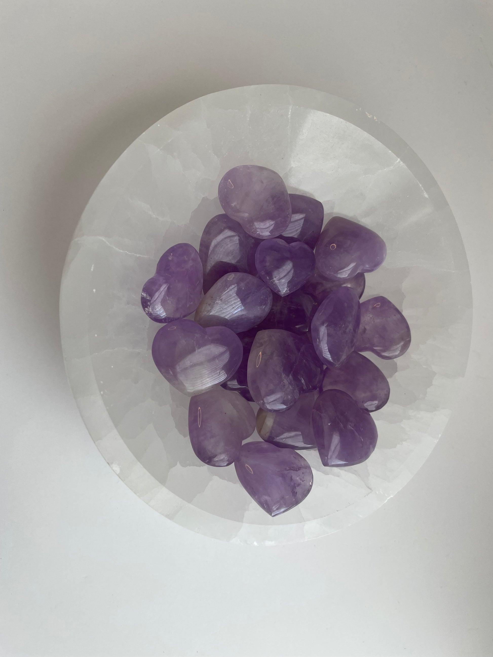 Purple crystals on a white stone surface.