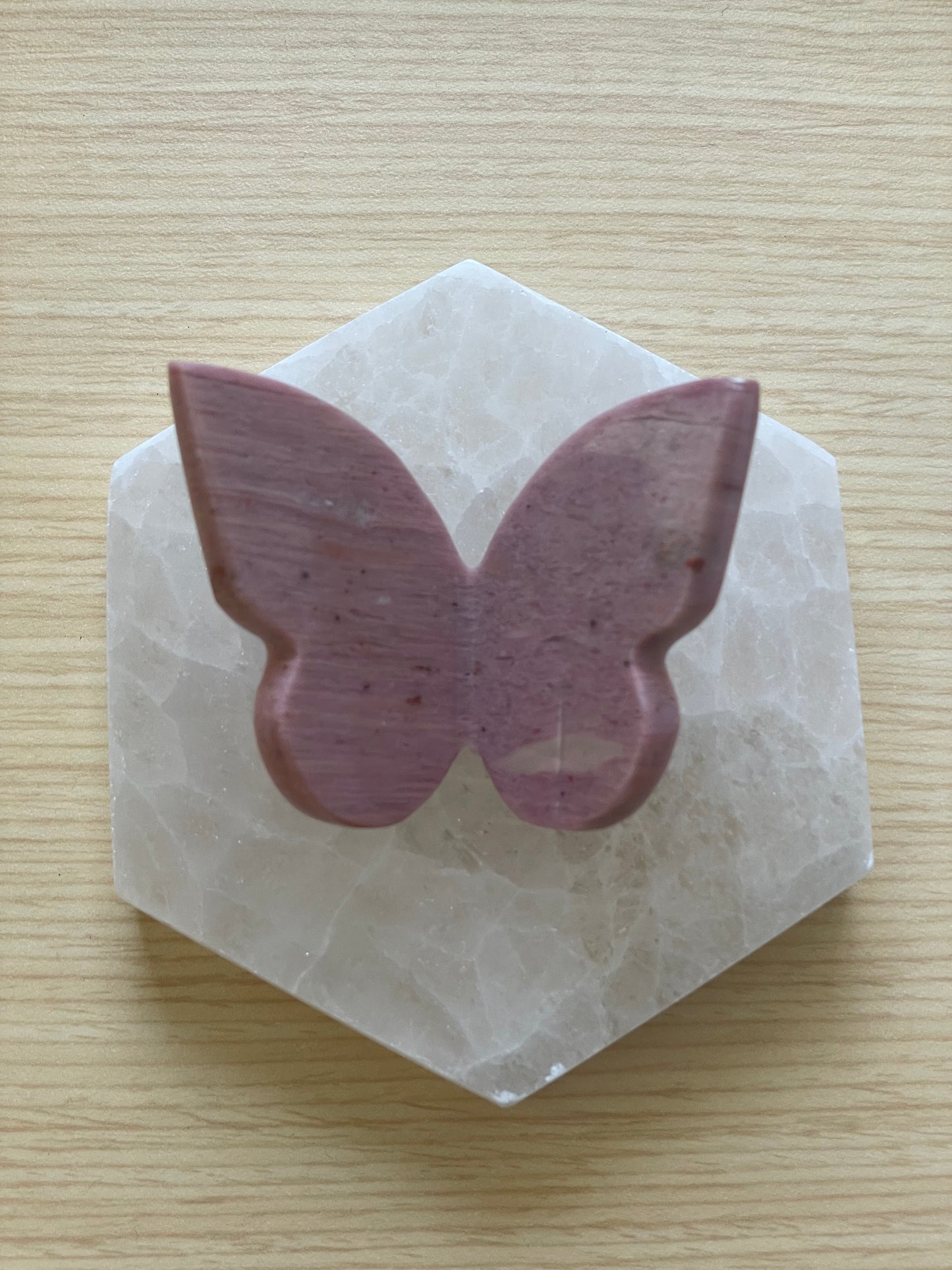 Butterfly-shaped purple stone on a hexagonal white stone