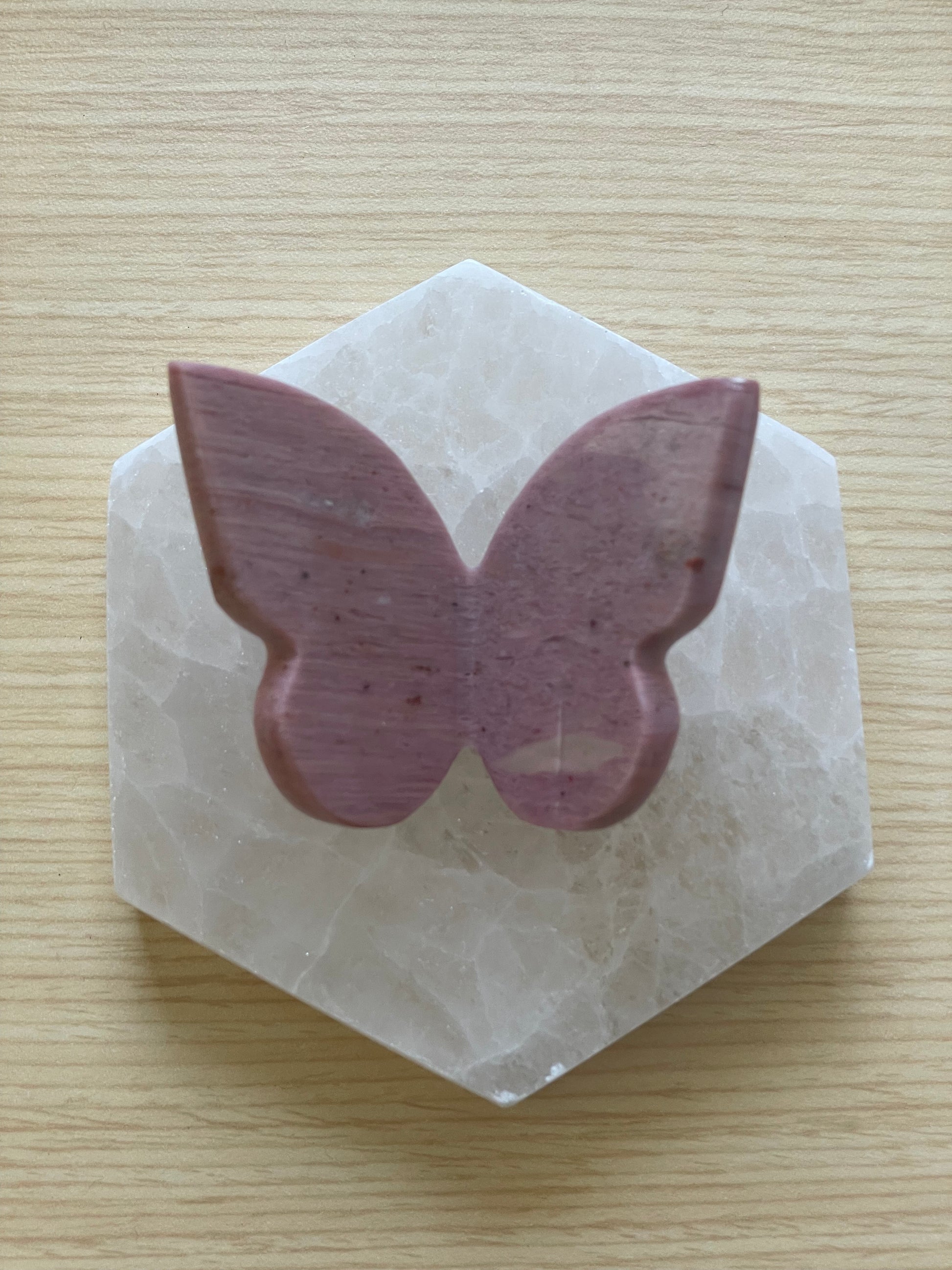 Butterfly-shaped purple stone on a hexagonal white stone
