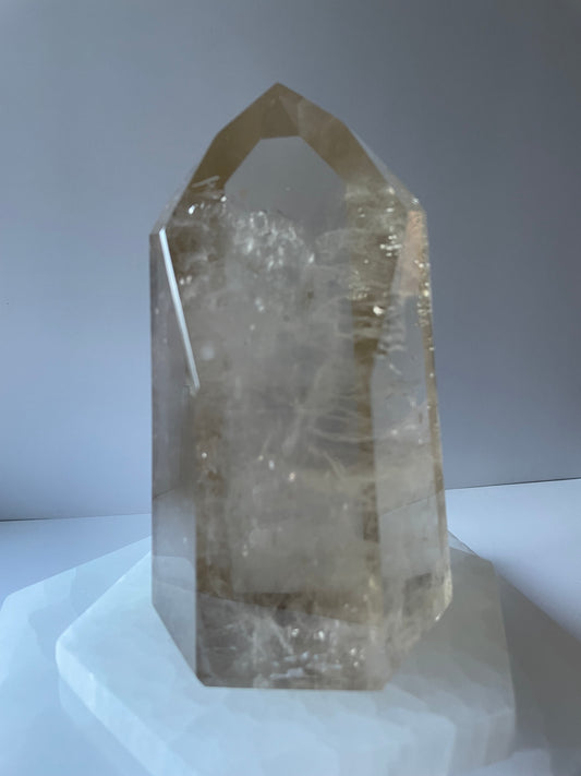 Large smoky quartz tower on white surface.